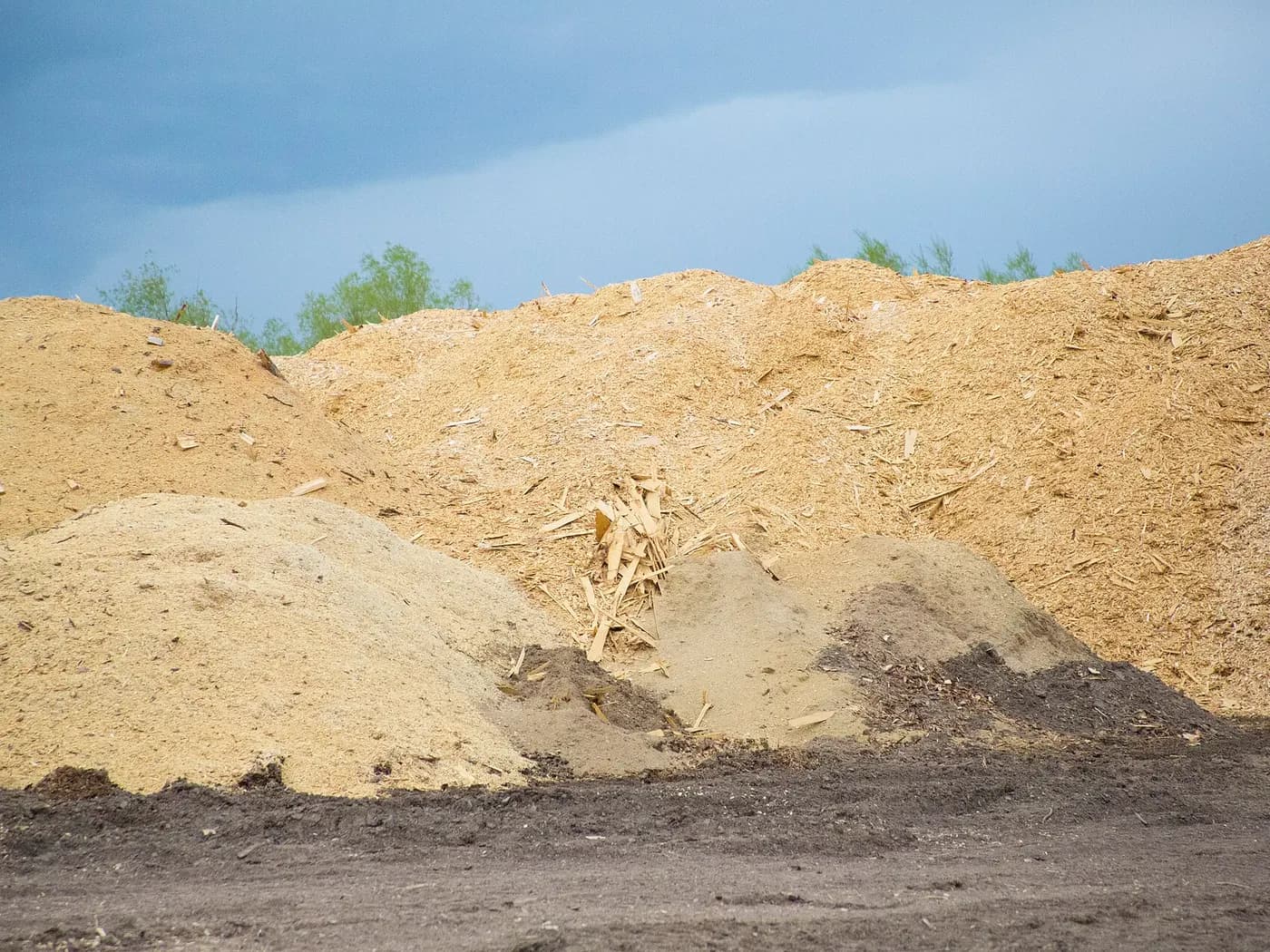 A pile of wood chips in an open yard